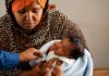 Private Hospitals Expand Access to Childhood Immunization in Somaliland A mother holds her newborn as a healthcare worker prepares to administer a routine vaccination at a health facility in Somaliland.