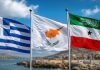 Greek and Cypriot Media Spotlight Somaliland’s Call for Strategic Partnership and Recognition Three national flags of Greece, Cyprus, and Somaliland waving on flagpoles against a bright blue sky and coastal landscape.