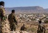 Somaliland-Somalia rivalry over fighters raises tensions around Erigavo Armed fighters in camouflage overlooking Erigavo city from a rocky hillside, with mountains and a mosque visible in the background.
